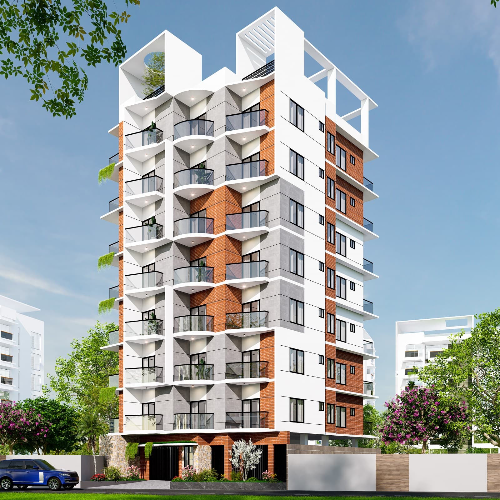 Completed corner apartment block in white render with terracotta brick banding and rounded balconies, black metal gate and hedge at the entrance